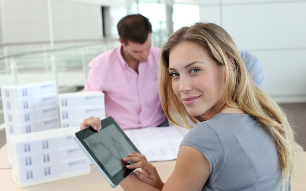 Beautiful woman in office using electronic tablet